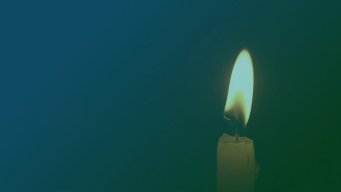 Single lit candle against a dark background